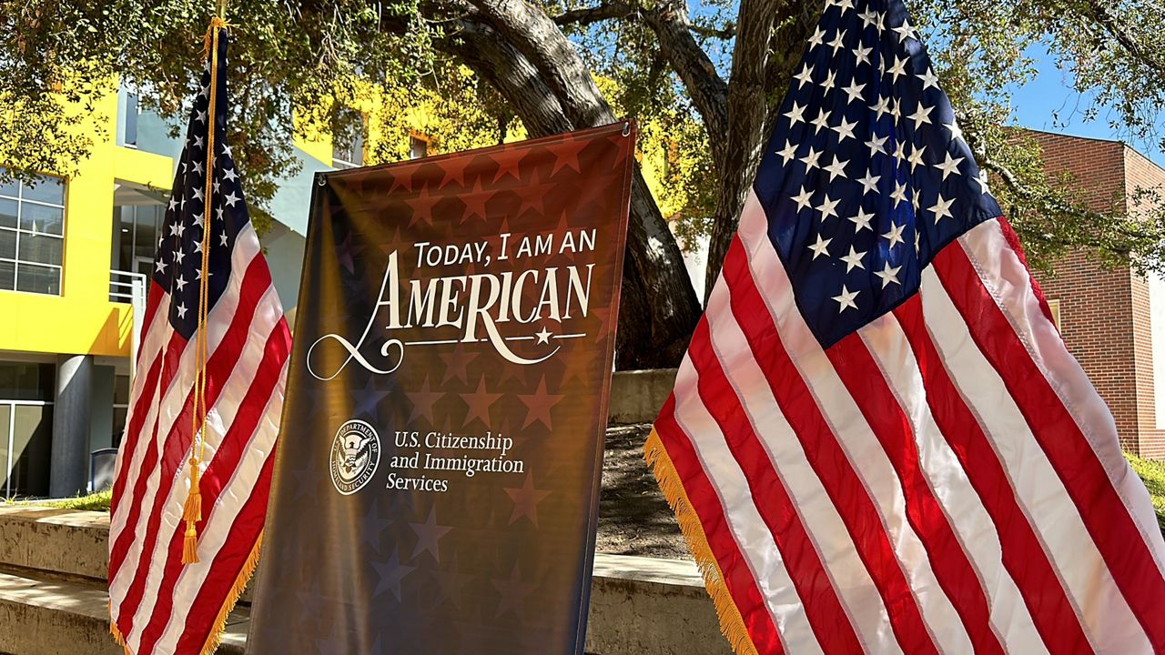 "today I am an American" on a banner with American flags to the left and right of it.