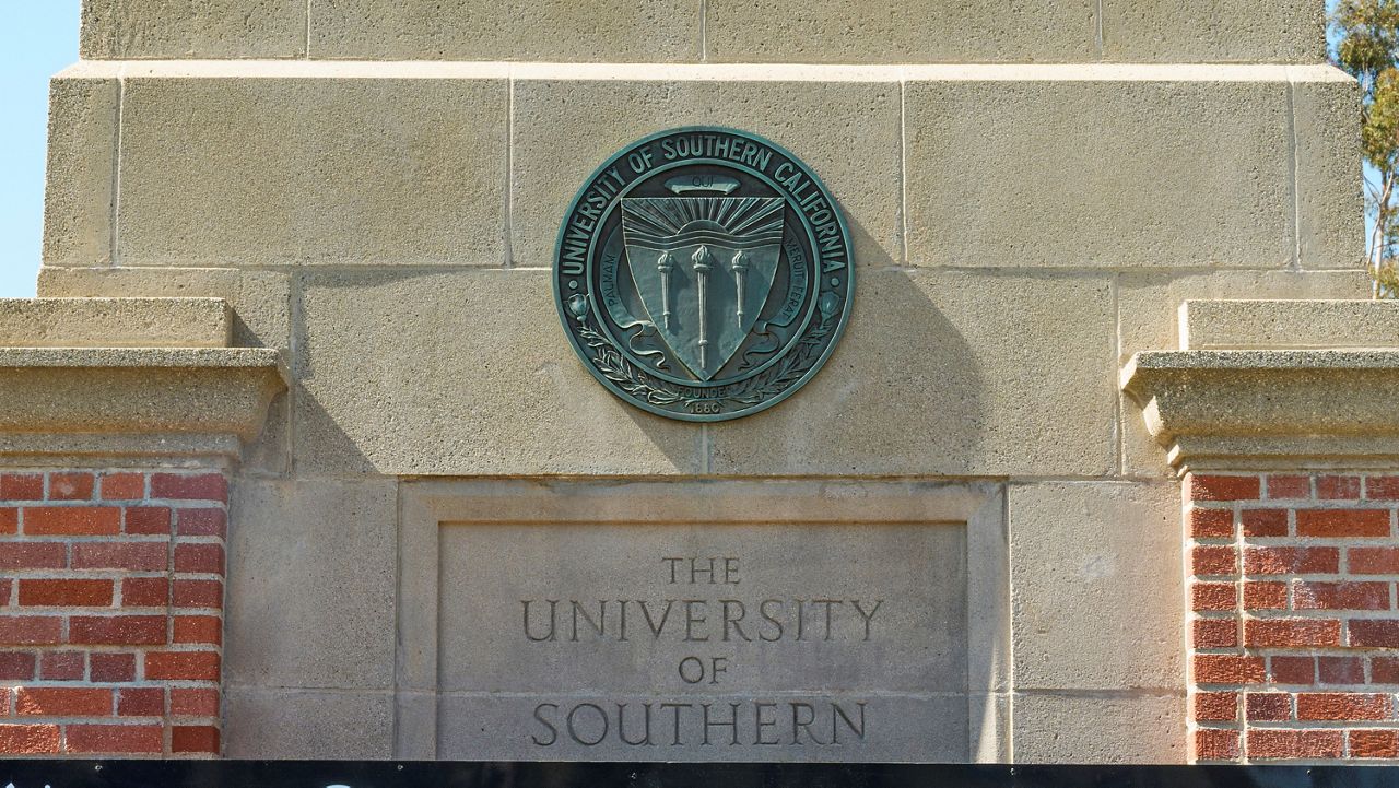 The emblem for the University of Southern California is mounted at a campus entrance in Los Angeles. (AP Photo/Damian Dovarganes)