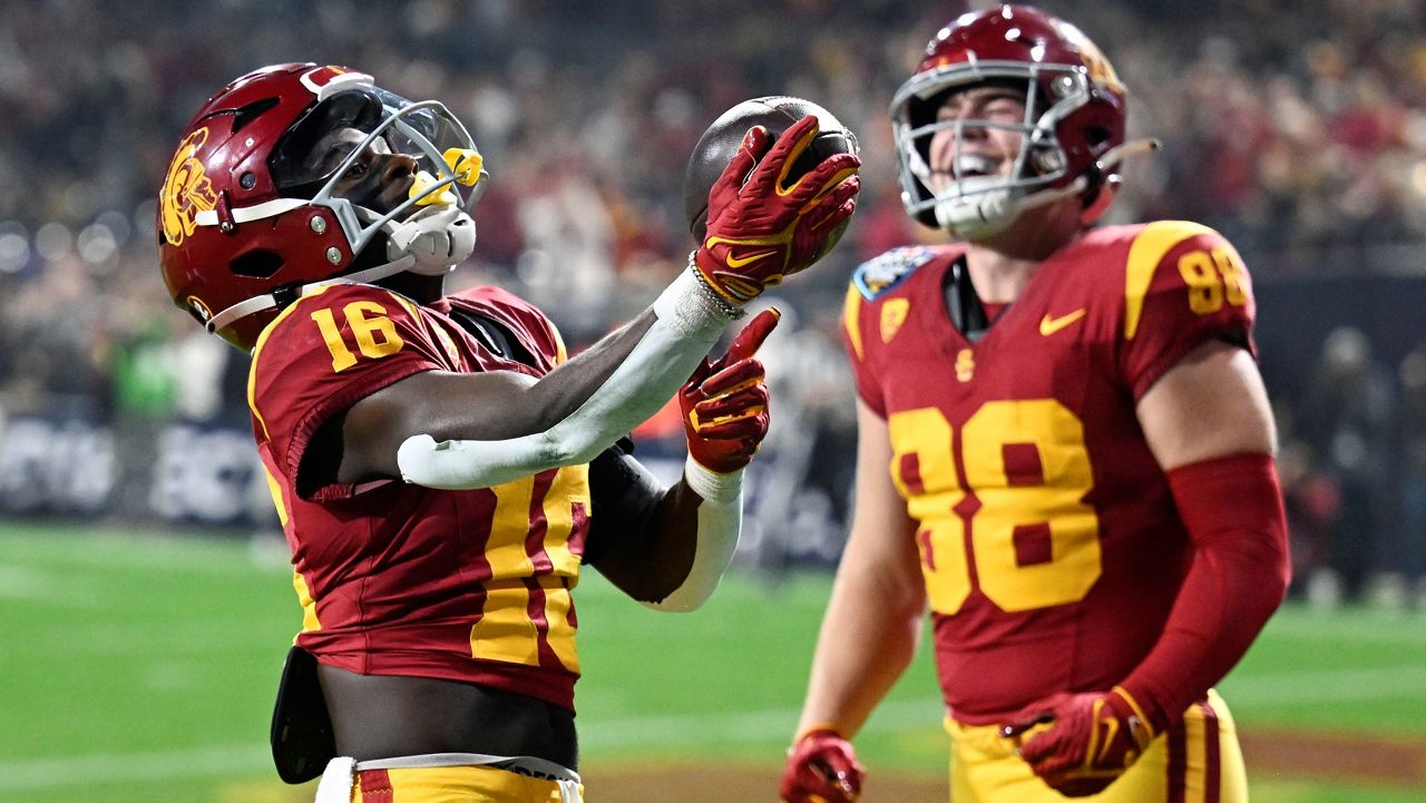 Southern California wide receiver Tahj Washington (16) celebrates a touchdown with tight end Kade Eldridge (88) during the first half of the Holiday Bowl NCAA college football game against Louisville Wednesday, Dec. 27, 2023, in San Diego. (AP Photo/Denis Poroy)