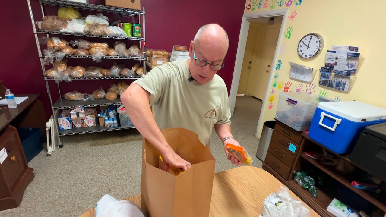 Volunteer Kenny Johnson helps pack bags at Good Samaritan Food Pantry, which has been helping feed the community since 1971. (Spectrum Bay News 9/Calvin Lewis)
