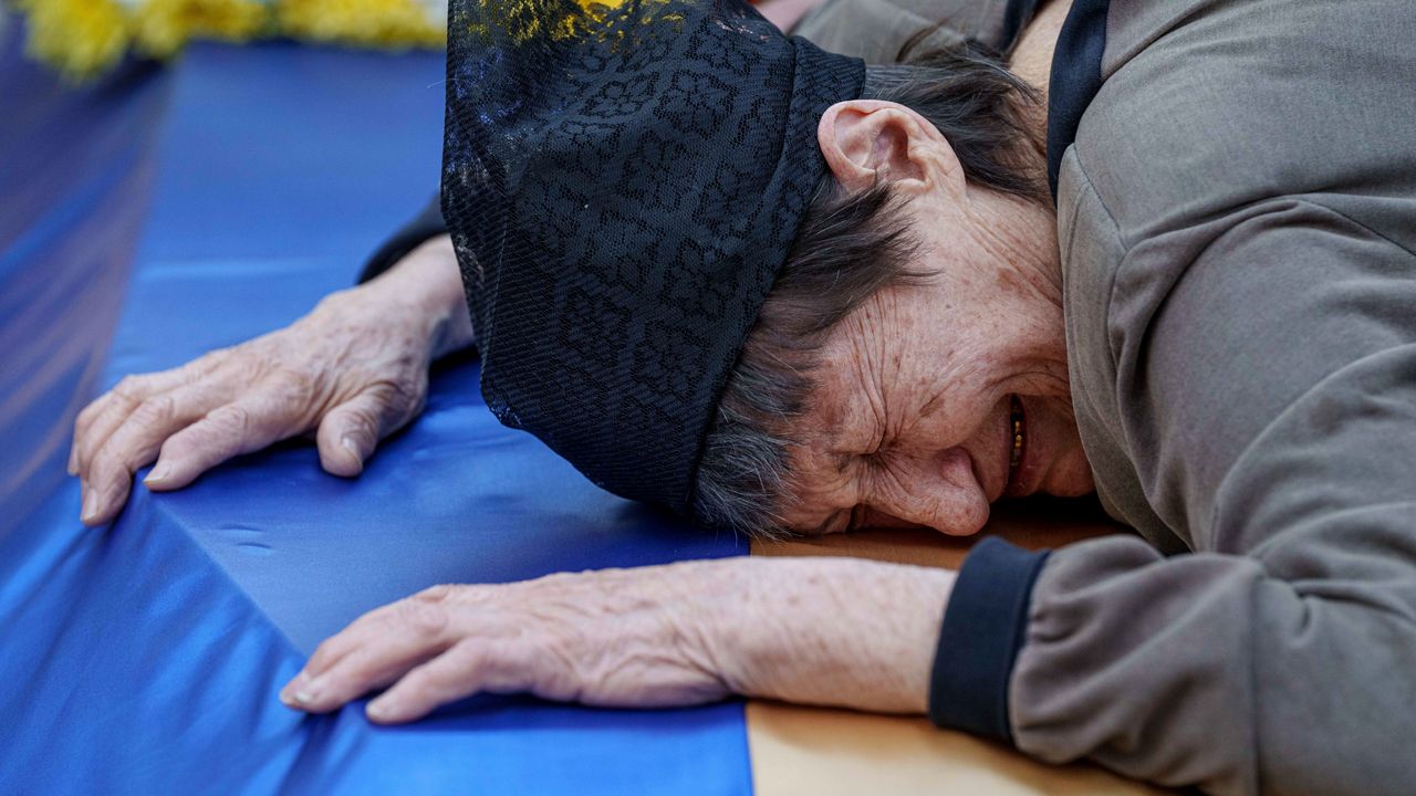 A mother cries near the coffin of her son killed in a Russian rocket attack at a Ukrainian military academy, during his funeral ceremony in Poltava, Ukraine, Saturday Sept. 7, 2024. (AP Photo/Evgeniy Maloletka)