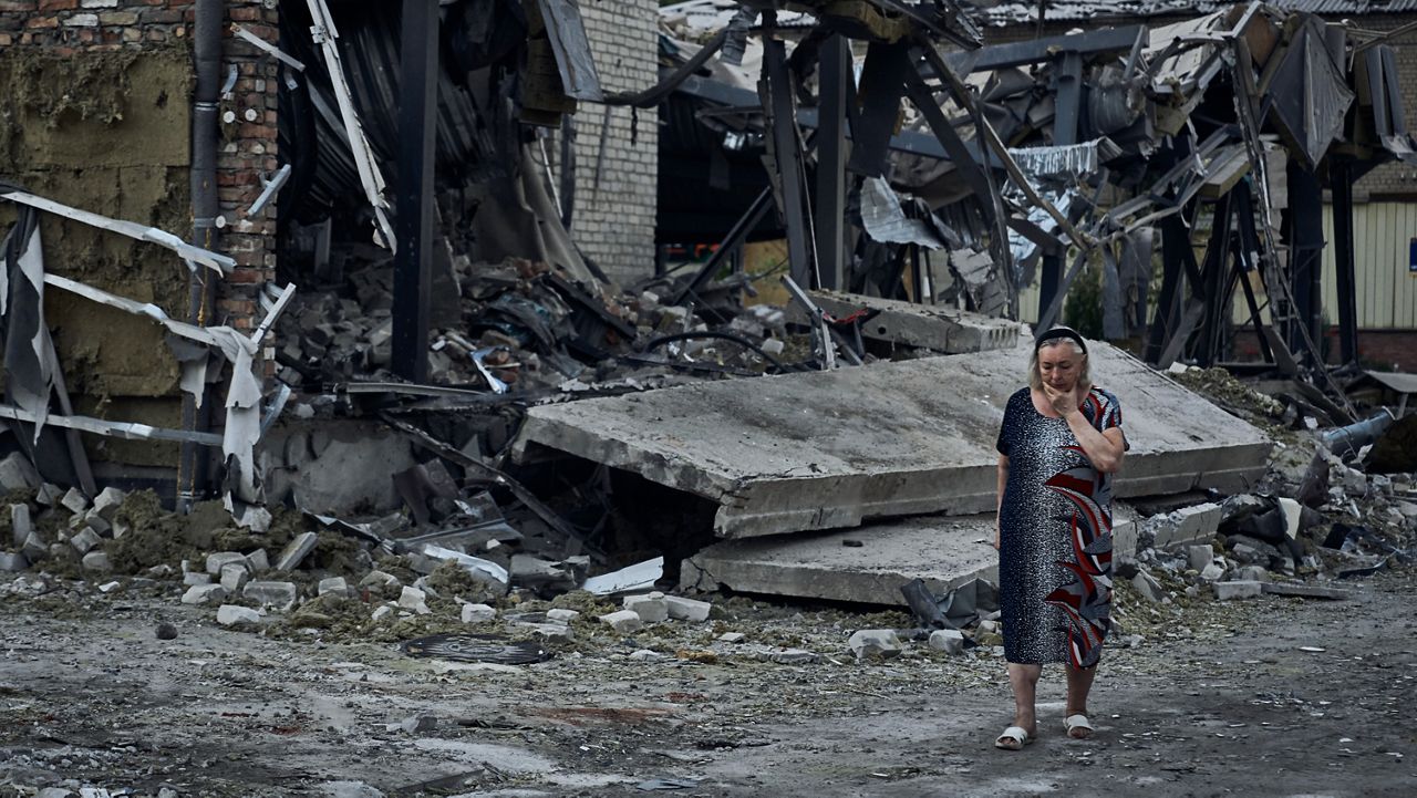 A woman reacts at the scene of a building damaged after recent Russian missile strikes in Pokrovsk, Donetsk region, Ukraine, , Wednesday, Aug. 9, 2023. (AP Photo/Libkos)