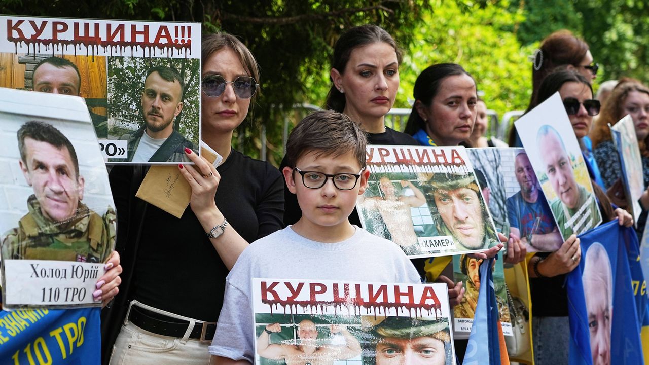 Family members of Ukrainian prisoners hold banners and photos of servicemen in captivity ahead of an exchange of prisoners between Russia and Ukraine, in Chernyhiv region, Ukraine, Friday, May 23, 2025. (AP Photo/Efrem Lukatsky)