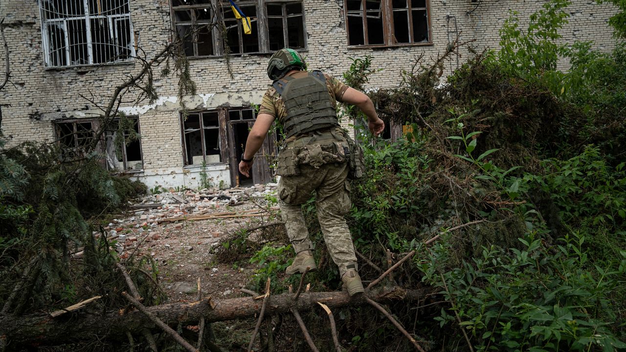 A Ukrainian serviceman of the 68th Oleksa Dovbush hunting brigade runs to his position in the recently retaken village of Blahodatne, Ukraine, Saturday, June 17, 2023. (AP Photo/Evgeniy Maloletka)