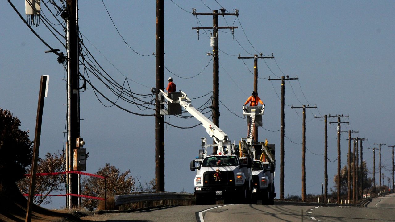 Utility crews repair overhead lines along Pacific Coast Highway just west of Malibu, Calif., on Nov. 25, 2018. (AP Photo/John Antczak, File)