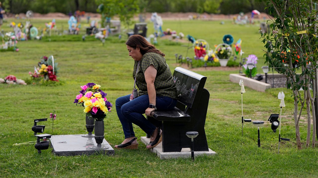 Veronica Mata visits the gravesite of her daugher, Tess, in Uvalde, Texas, Wednesday, May 3, 2023. For Mata, teaching kindergarten in Uvalde after her daughter was among the 19 students who were fatally shot at Robb Elementary School became a year of grieving for her own child while trying to keep 20 others safe. (AP Photo/Eric Gay)