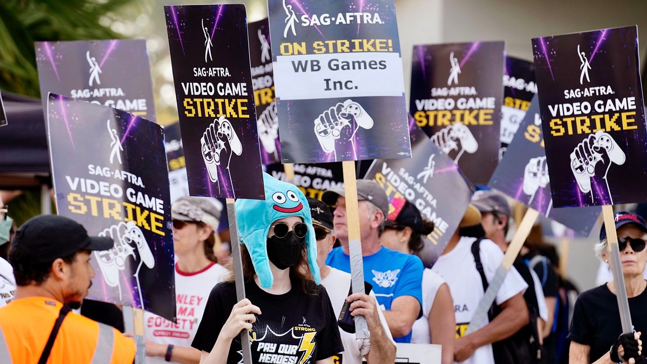 Actor Sena Bryer, second from left, joins other demonstrators in a SAG-AFTRA video game actor strike picket line outside Warner Bros. Studios on Wednesday, Aug. 28, 2024, in Burbank, Calif. (AP Photo/Chris Pizzello)