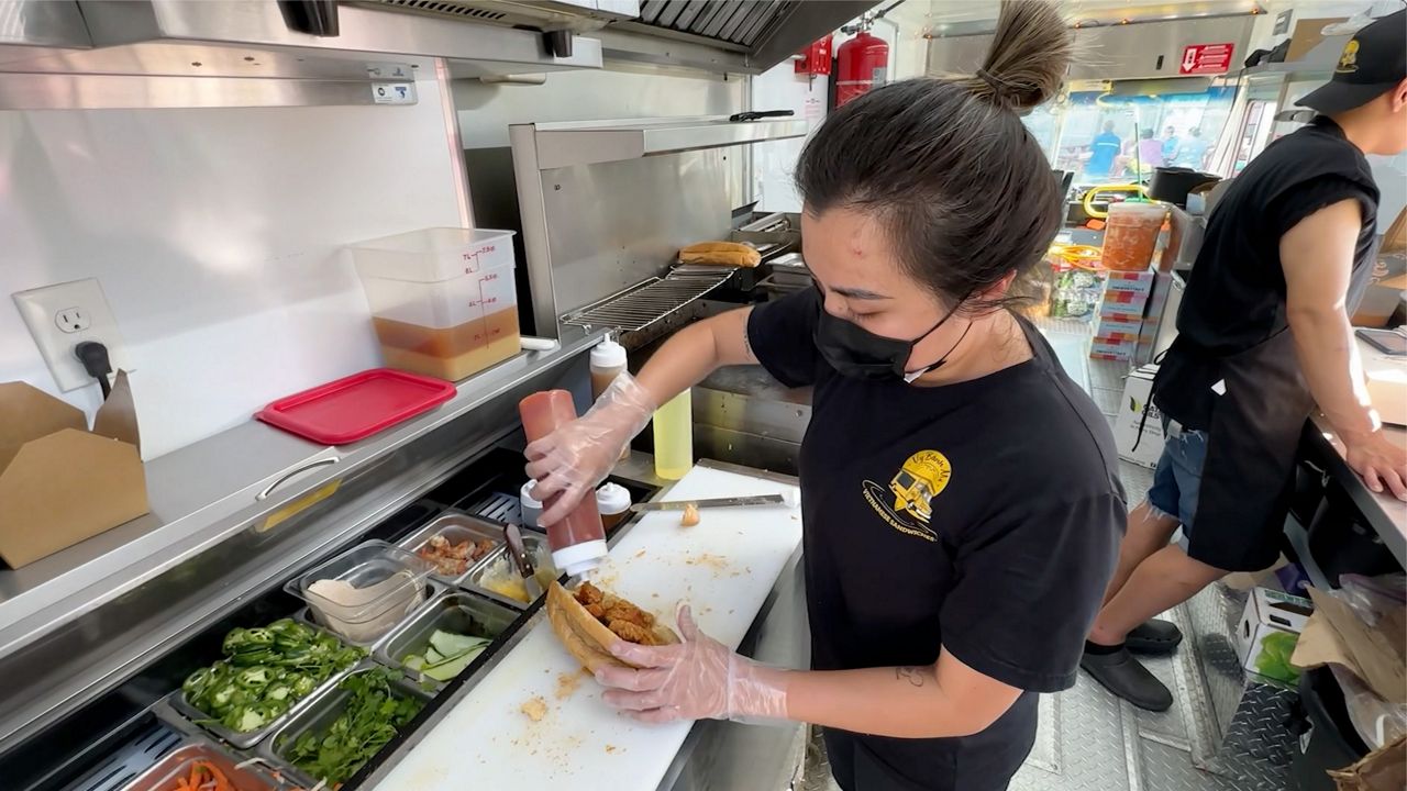 Vy Phan, 30, prepares a Vietnamese sandwich inside her food truck, Vy Banh Mi, parked at Congdon's After Dark in Wells Thursday. The food truck park has been active since 2017. (Spectrum News/Sean Murphy)