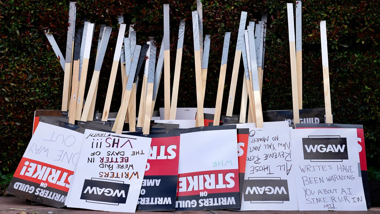 Placards are gathered together at the close of a picket by members of The Writers Guild of America outside Walt Disney Studios, Tuesday, May 2, 2023, in Burbank, Calif. On Sunday, Sept. 24, 2023, a tentative deal was reached to end Hollywood’s writers strike after nearly five months. (AP Photo/Chris Pizzello)