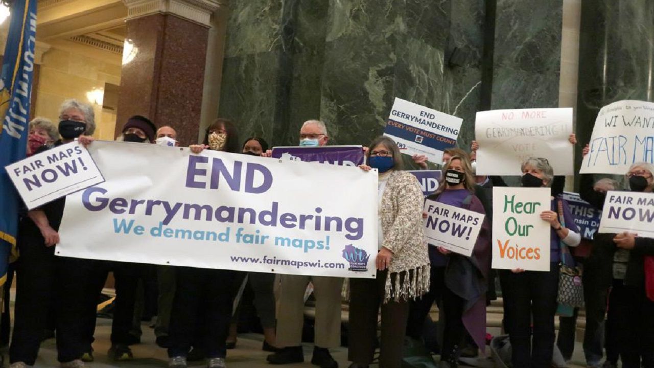 More than 100 opponents of the Republican redistricting plans vow to fight the maps at a rally ahead of a joint legislative committee hearing in the Wisconsin state Capitol in Madison, Wis. on Thursday, Oct. 28, 2021. (AP Photo/Scott Bauer)