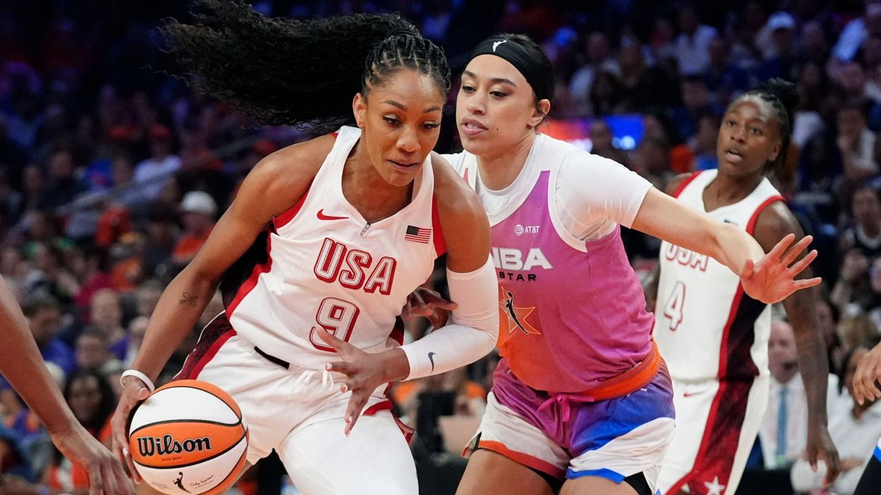 A'ja Wilson (9), of Team USA, drives past Dearica Hamby, front right, of Team WNBA, during the first half of a WNBA All-Star basketball game Saturday, July 20, 2024, in Phoenix. (AP Photo/Ross D. Franklin)