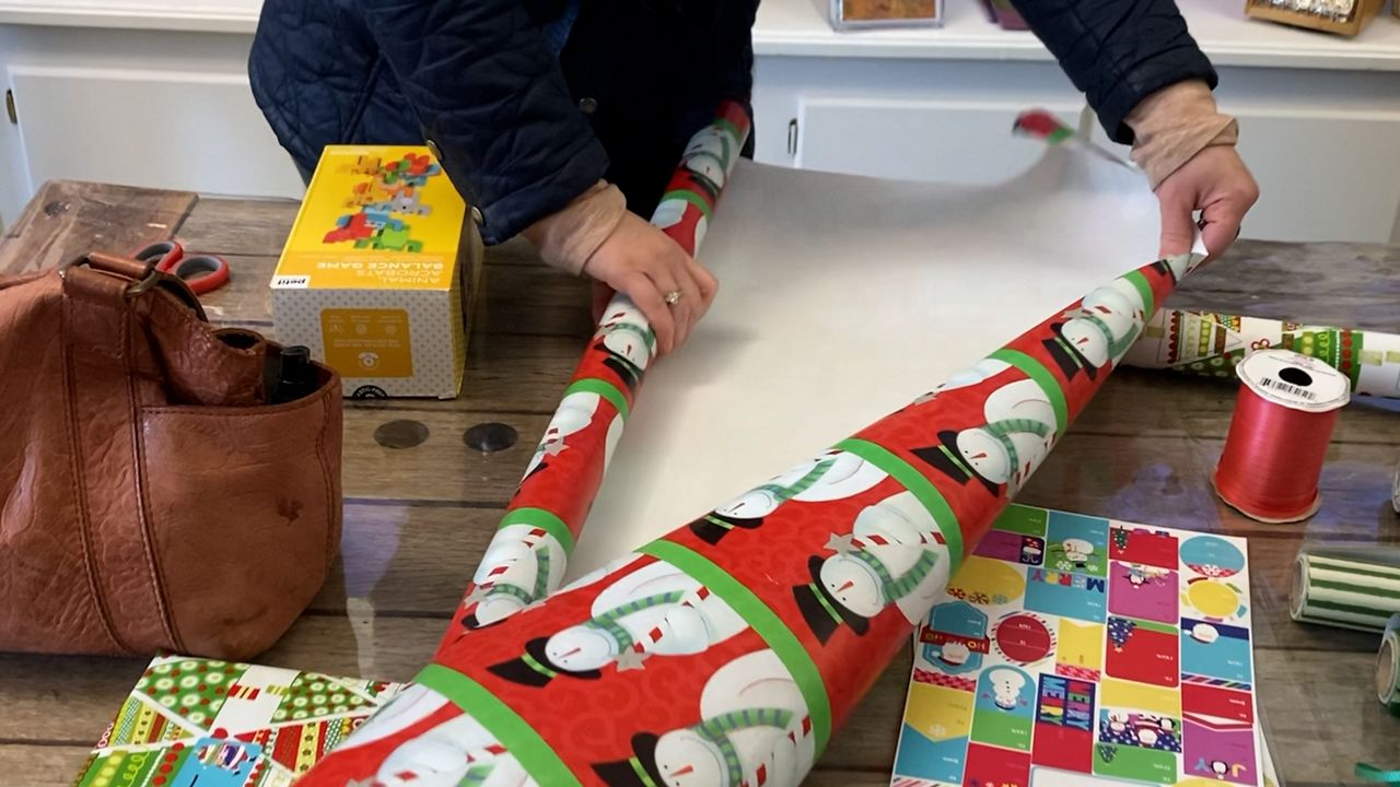 A customer wraps a gift at C.C. Lowell Art Supply Co on Sunday. (Spectrum News 1/Devin Bates)