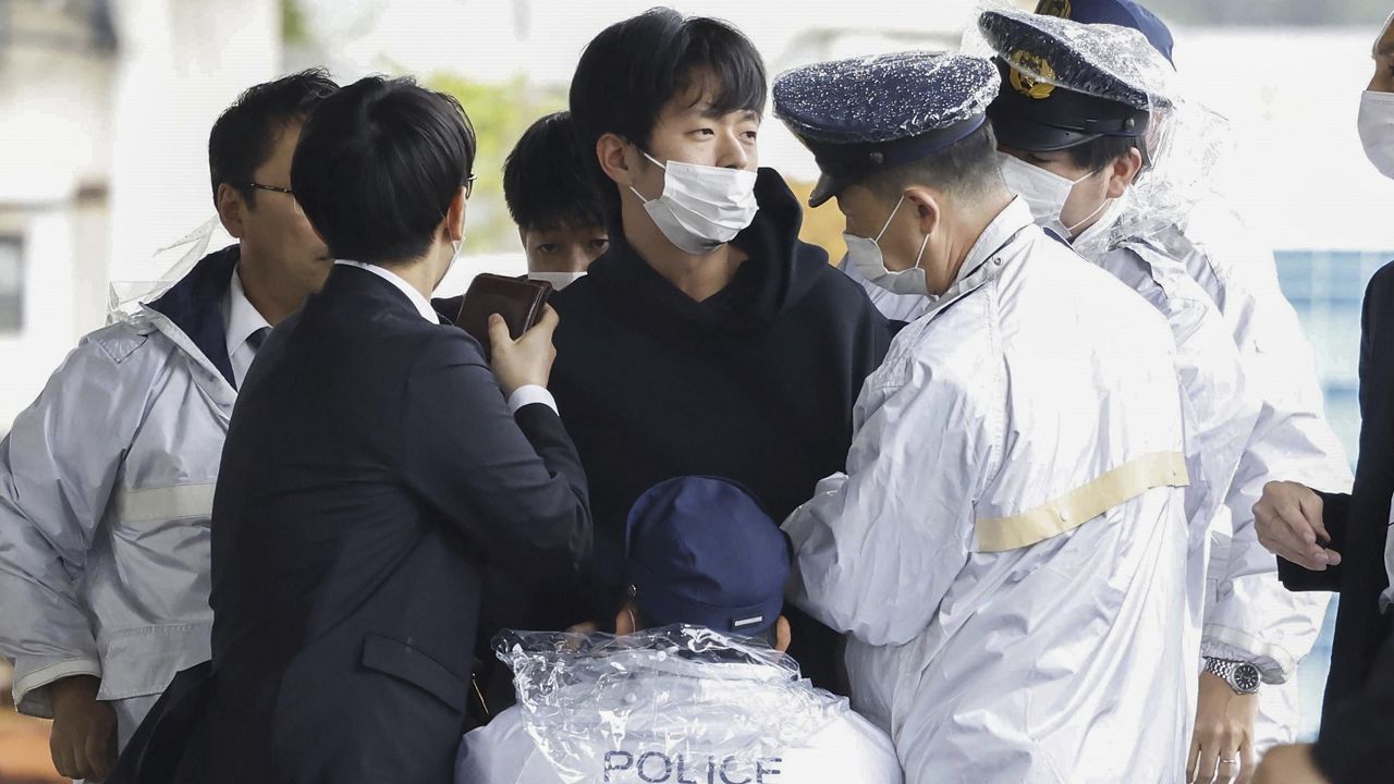 A man, center, who threw what appeared to be a smoke bomb, is caught at a port in Wakayama, western Japan Saturday, April 15, 2023. Japan’s NHK television reported Saturday that a loud explosion occurred at the western Japanese port during Prime Minister Fumio Kishida’s visit, but there were no injuries. (Kyodo News via AP)