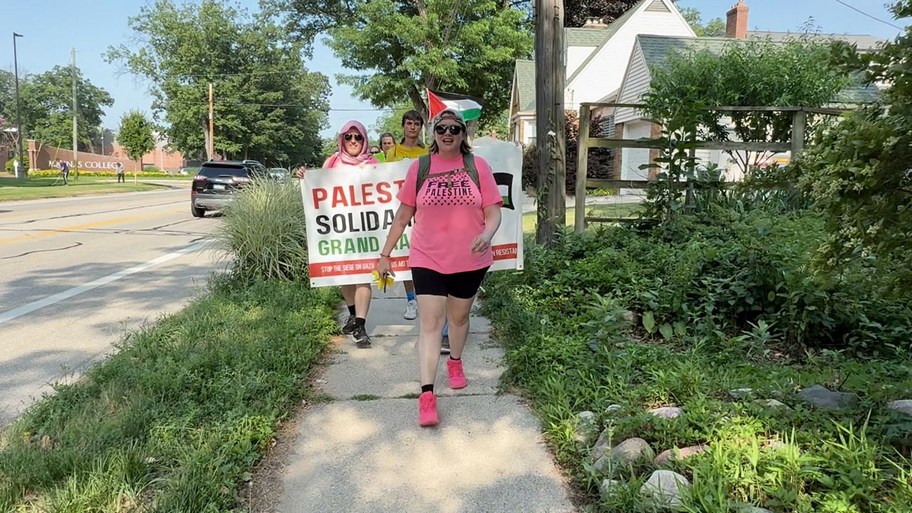 Protesters marching from Grand Rapids to Lansing carry a sign in support of Palestine in this image from June 26, 2025. (Spectrum News/Brian Farber)