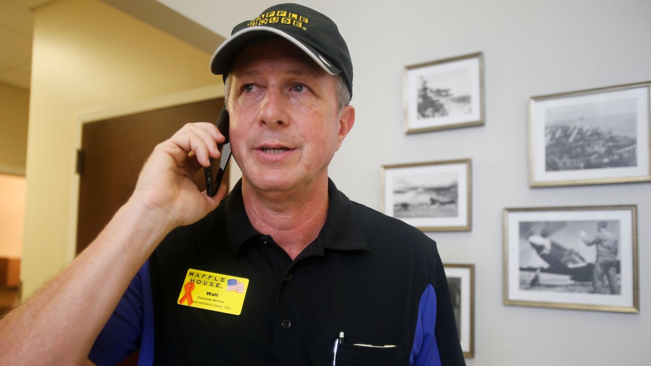 Walt Ehmer, president and CEO of Waffle House, speaks on the phone after landing at the Wilmington airport with an emergency response team in Wilmington, N.C., Sept. 17, 2018. (AP Photo/Steve Helber, File)