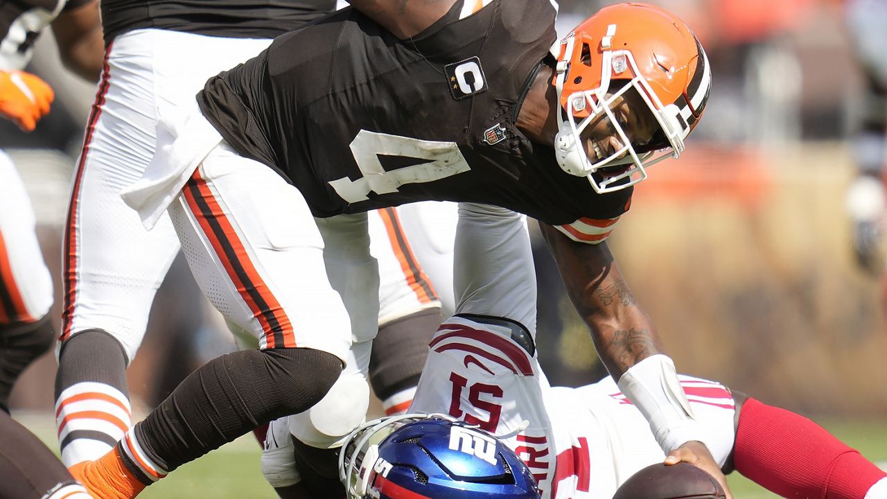 New York Giants linebacker Azeez Ojulari, bottom, sacks Cleveland Browns quarterback Deshaun Watson (4) during the second half of an NFL football game, Sunday, Sept. 22, 2024, in Cleveland. (AP Photo/Sue Ogrocki)