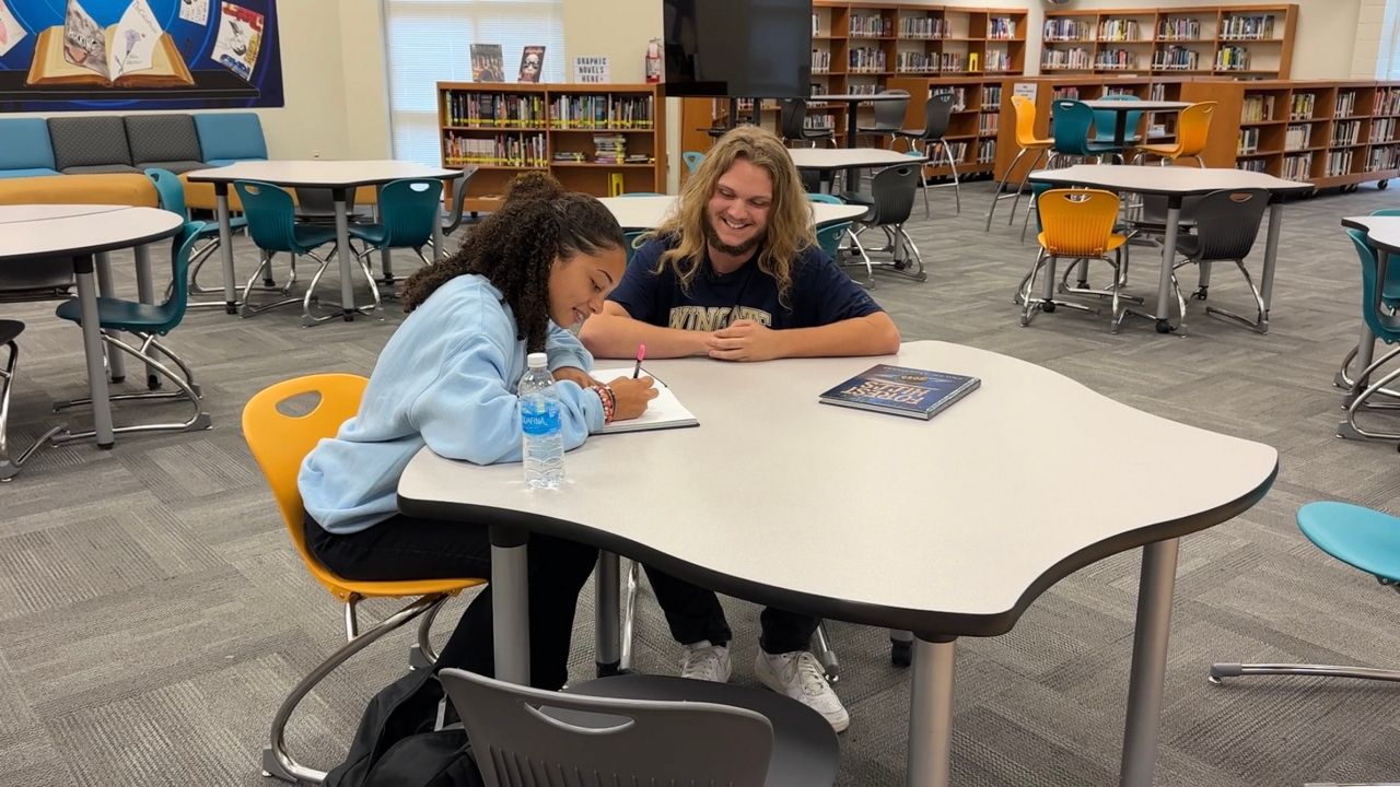 Tessa Stewart and Carson Corley in the library