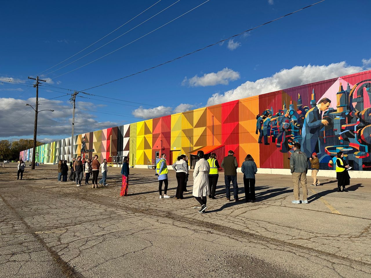 Photo of Wisconsin's largest mural in Oshkosh with people standing in front of it looking at the mural.