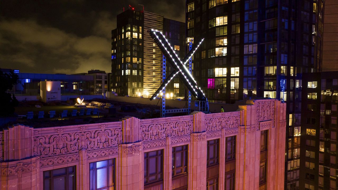 Workers install lighting Friday on an "X" sign atop the company headquarters, formerly known as Twitter, in downtown San Francisco. (AP Photo/Noah Berger)