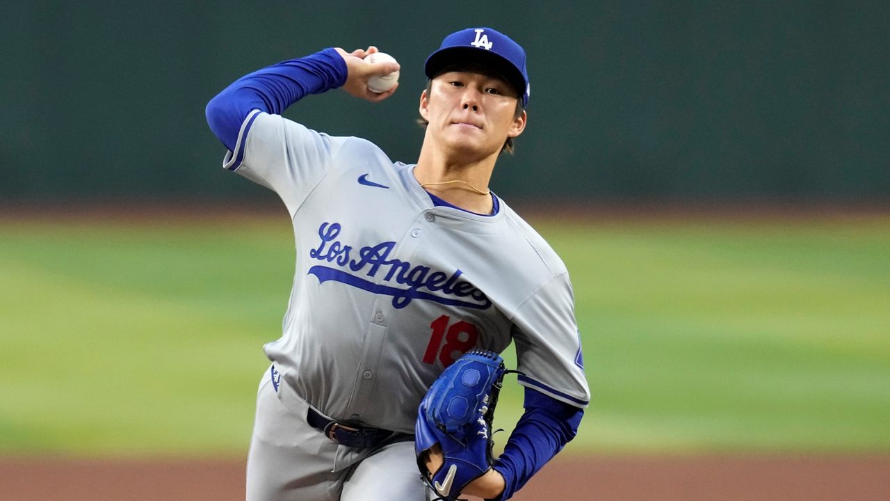 Los Angeles Dodgers' Shohei Ohtani, center, hits a solo home run as Kansas City Royals starting pitcher Brady Singer, left, and home plate umpire Ryan Additon watch during the sixth inning of a baseball game Sunday, June 16, 2024, in Los Angeles. (AP Photo/Mark J. Terrill)