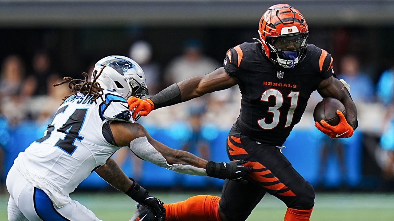 Cincinnati Bengals running back Zack Moss runs past Carolina Panthers linebacker Shaq Thompson during the second half of an NFL football game, Sunday, Sept. 29, 2024, in Charlotte, N.C. (AP Photo/Rusty Jones)