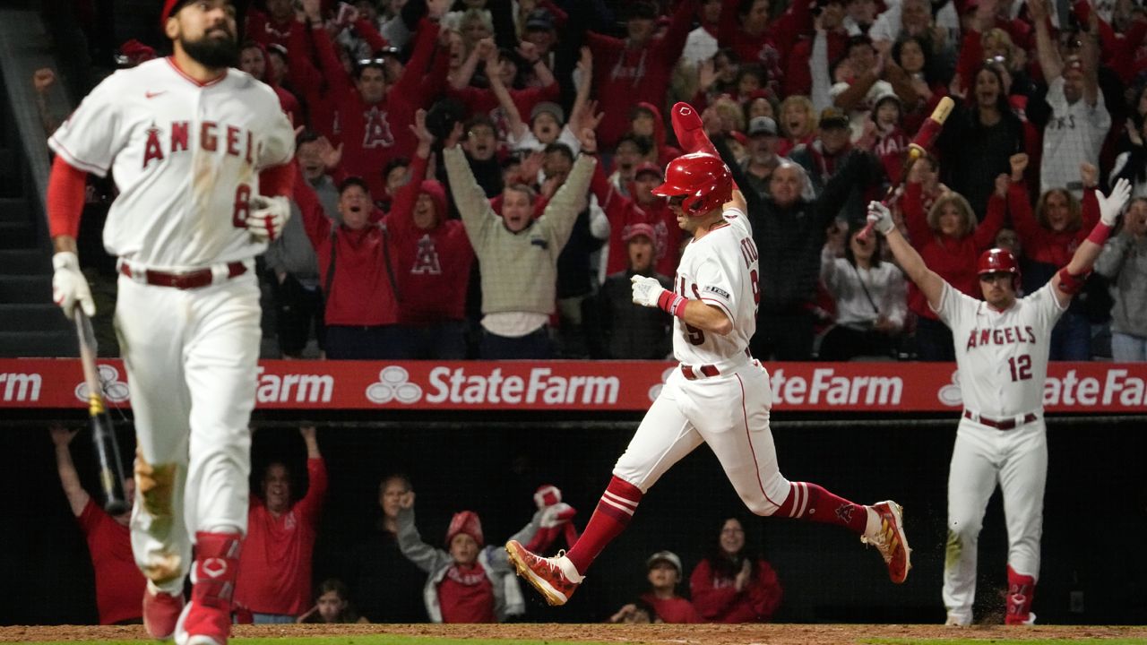 Los Angeles Angels' Zach Neto, center, celebrates as he scores to win the game after a wild pitch by Texas Rangers relief pitcher Josh Sborz as Anthony Rendon, left, runs to first and Hunter Renfroe also celebrates during the 10th inning of a baseball game Friday, May 5, 2023, in Anaheim, Calif. (AP Photo/Mark J. Terrill)