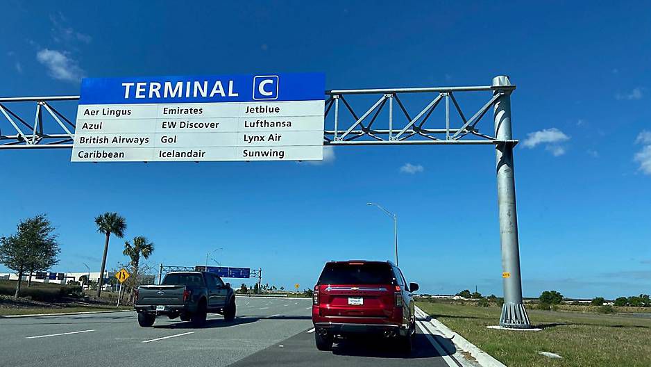 Drivers pass under a sign directing travelers to Terminal C at Orlando International Airport. (Spectrum News)