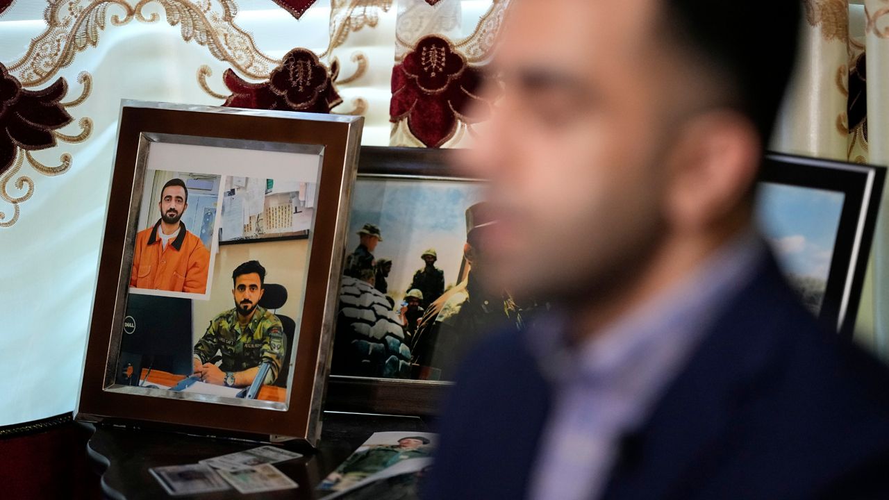 Photographs of Abdul Wasi Safi sit on a table as his brother, Sami-ullah Safi talks about his brother's journey to the U.S. during an interview Wednesday, Jan. 18, 2023, in Houston. Abdul Wasi Safi was an intelligence officer with the Afghan National Security Forces, providing U.S. armed forces with information for operations against terrorists, said Sami-ulllah Safi. Wasi, as he is called by his family, was arrested after crossing the U.S.-Mexico border near Eagle Pass, Texas in September 2022, and charged with a federal misdemeanor related to wrongly entering the country and placed in a detention center in Central Texas. (AP Photo/David J. Phillip)