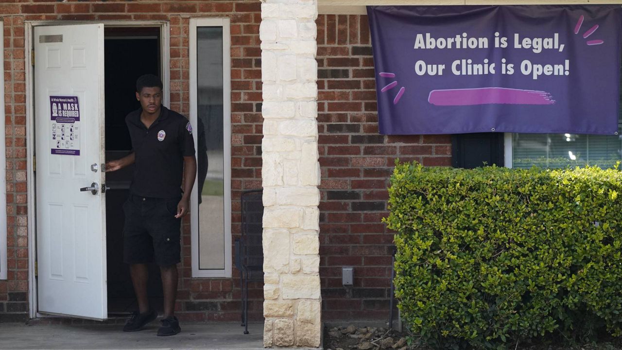 Texas abortion clinic with a man holding the door open. (AP Images)