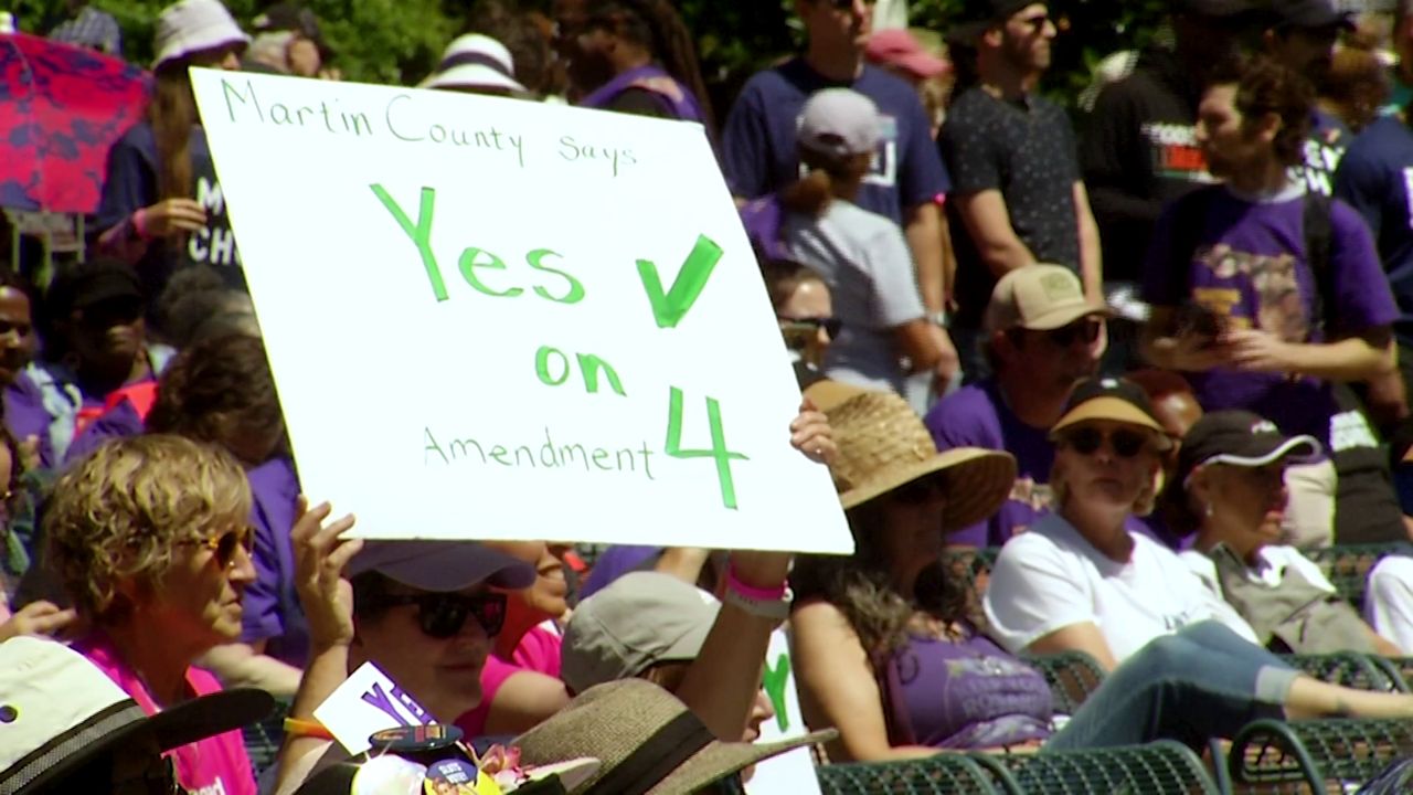 An abortion rights advocate holds up a sign at Lake Eola Park on April 13, 2024, in support of an amendment initiative that would protect abortion up to roughly 24 weeks in Florida. (Spectrum News)
