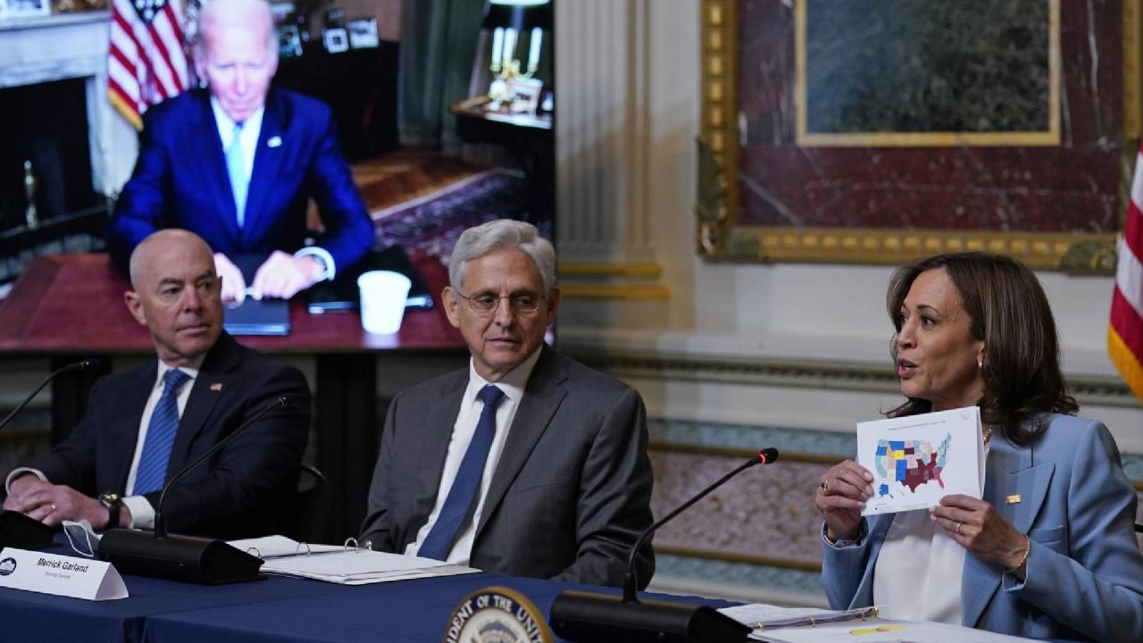 Vice President Kamala Harris, right, holds up a map as she speaks in the Indian Treaty Room on the White House complex in Washington, Wednesday, Aug. 3, 2022, during the first meeting of the interagency Task Force on Reproductive Healthcare Access. President Joe Biden attends virtually and Homeland Security Secretary Alejandro Mayorkas, left, and Attorney General Merrick Garland, center, attend in person. (AP Photo/Susan Walsh)