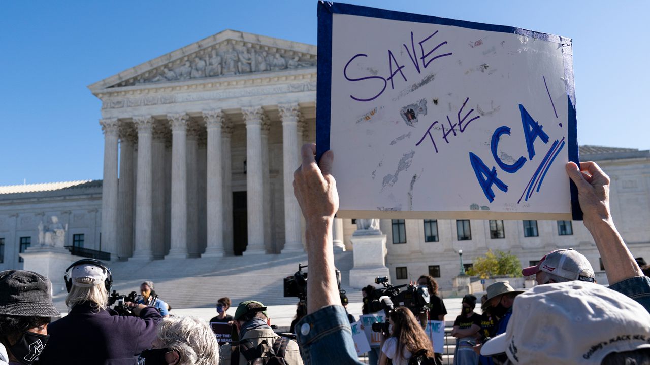 A demonstrator holds a sign in front of the U.S. Supreme Court as arguments are heard about the Affordable Care Act Tuesday, Nov. 10, 2020, in Washington. (AP Photo/Alex Brandon)