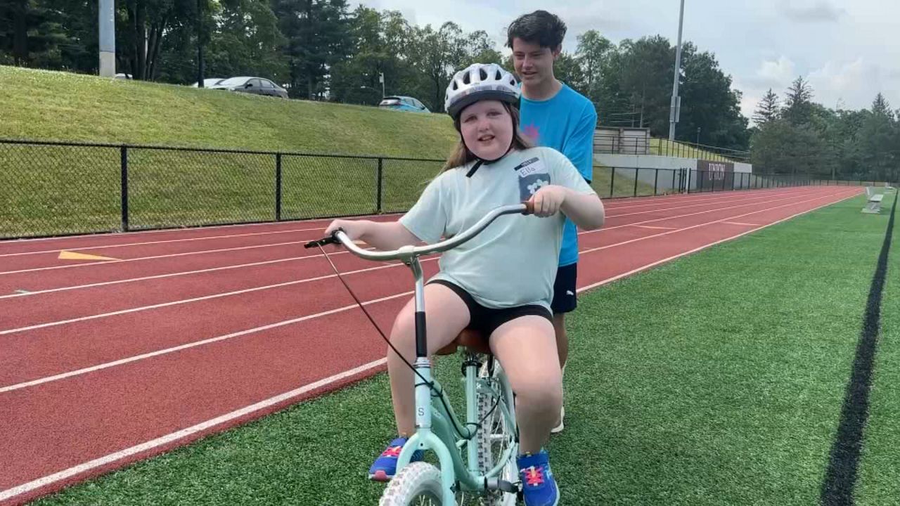 kid riding bike with help from adult