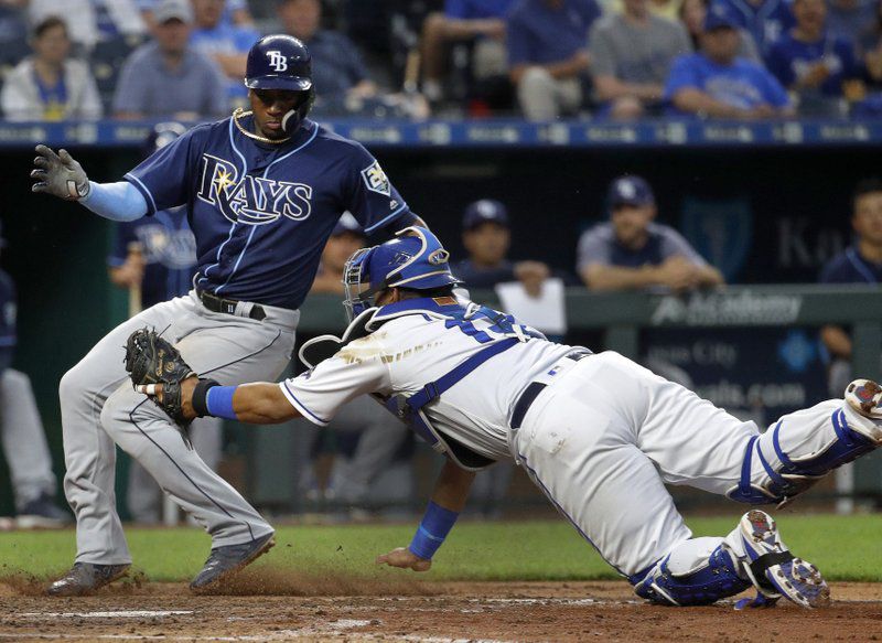 Tampa Bay Rays’ Adeiny Hechavarria beats the tag by Kansas City Royals catcher Salvador Perez to score on a single hit by Matt Duffy during the sixth inning of a baseball game Monday, May 14, 2018, in Kansas City, Mo. (AP Photo/Charlie Riedel)