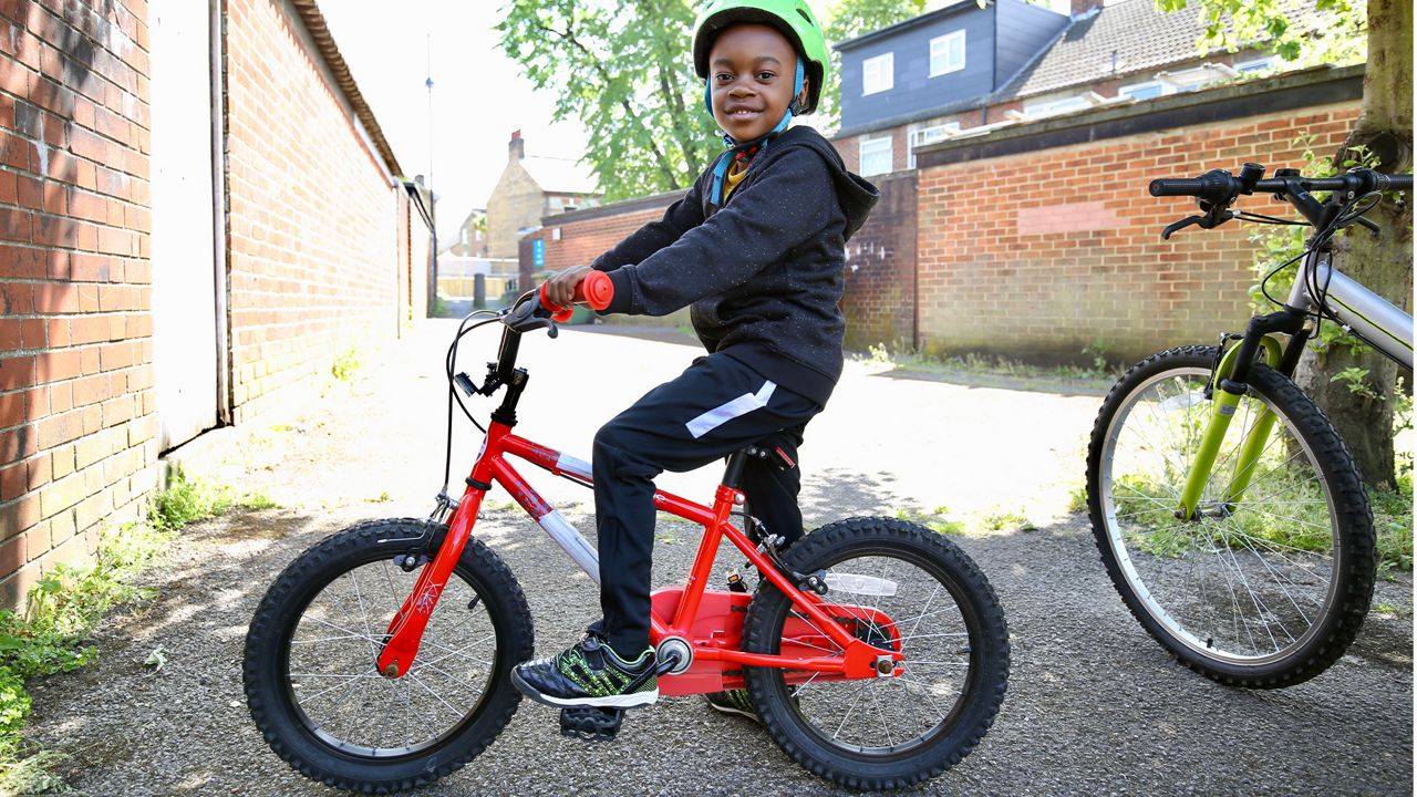 A kid on a bike smiling