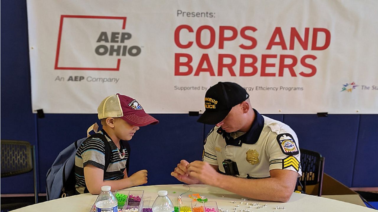 A Columbus Officer makes bracelets with a student. (Photo Courtesy The Starfish Assignment)