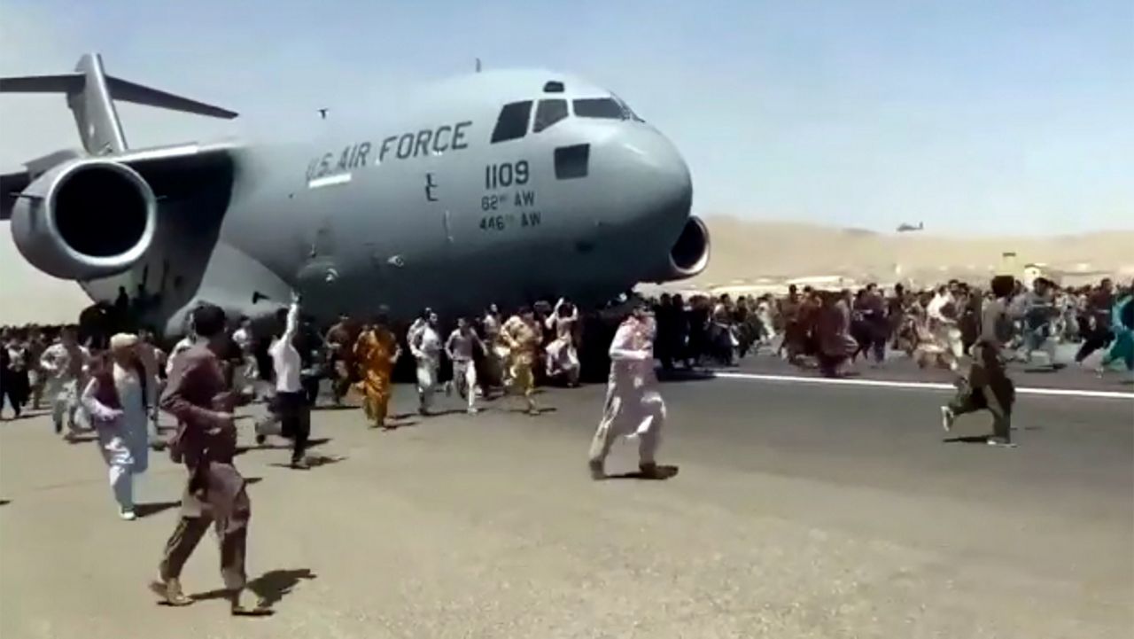 Hundreds of people run alongside a U.S. Air Force C-17 transport plane as it moves down a runway of the international airport, in Kabul, Afghanistan. on Aug. 16, 2021 (AP)