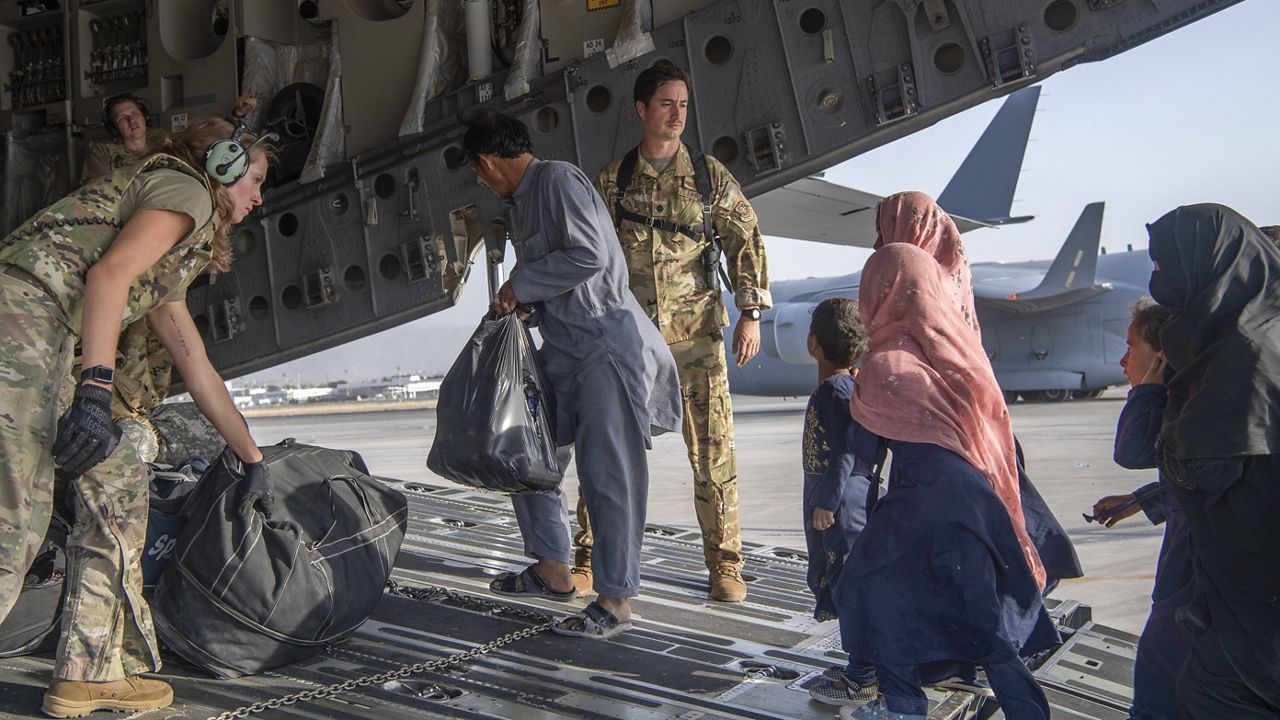 Several Afghan people board a flight out of Afghanistan. (Associated Press)