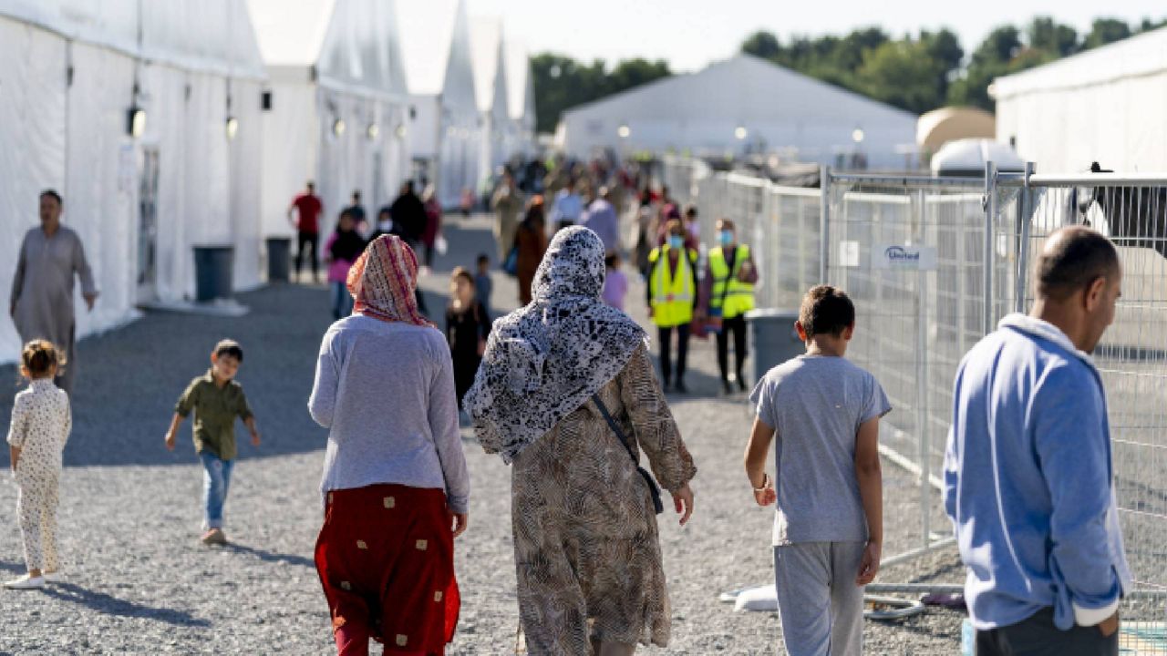 FILE - Afghan refugees walk through an Afghan refugee camp at Joint Base McGuire Dix Lakehurst, N.J., on Sept. 27, 2021. (AP Photo/Andrew Harnik, File)