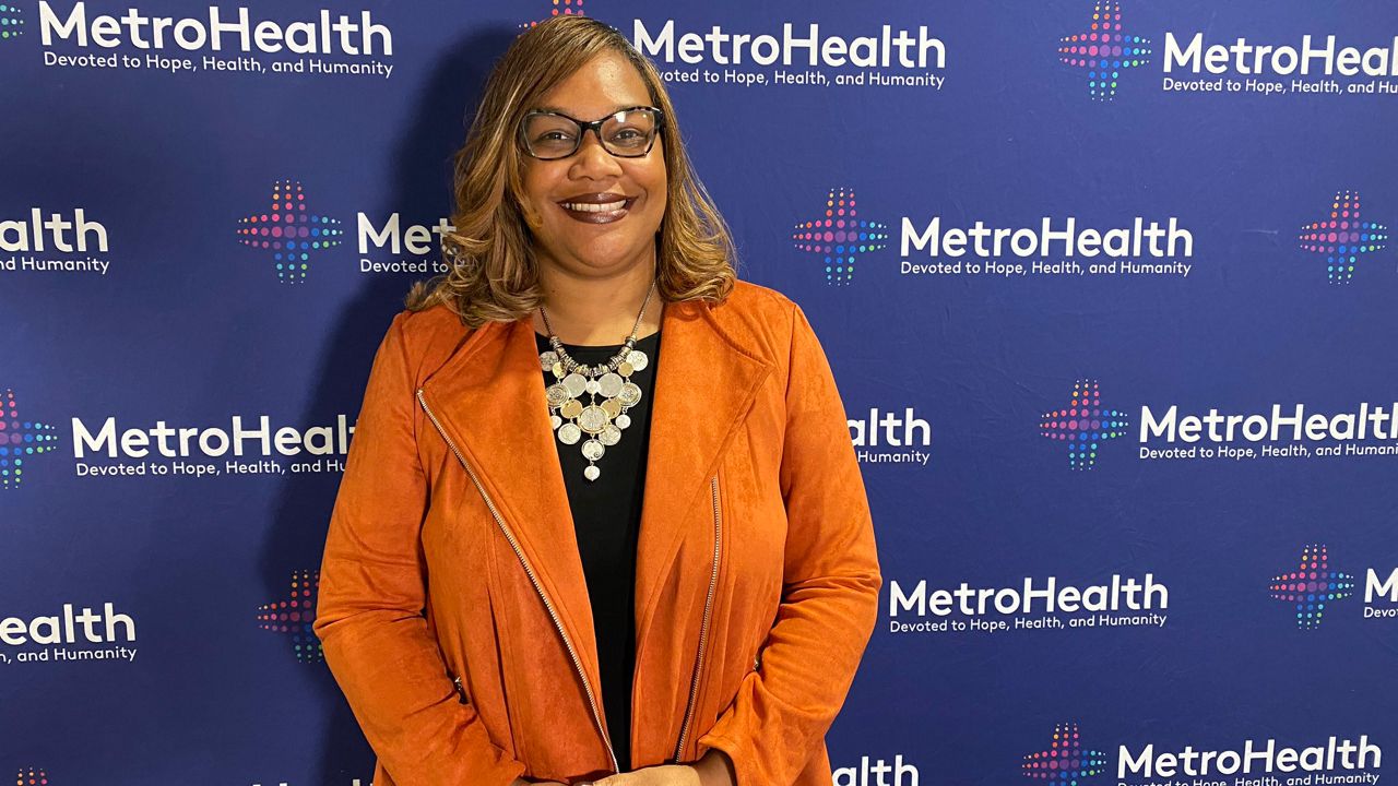 Dr. Airica Steed stands smiling in front of a MetroHealth backdrop.