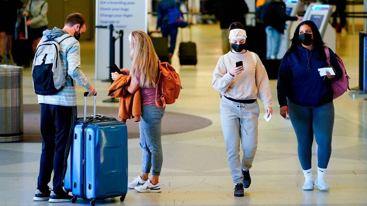 Travelers wearing masks move about the a terminal at the Philadelphia International Airport in Philadelphia on Tuesday. (AP Photo/Matt Rourke)