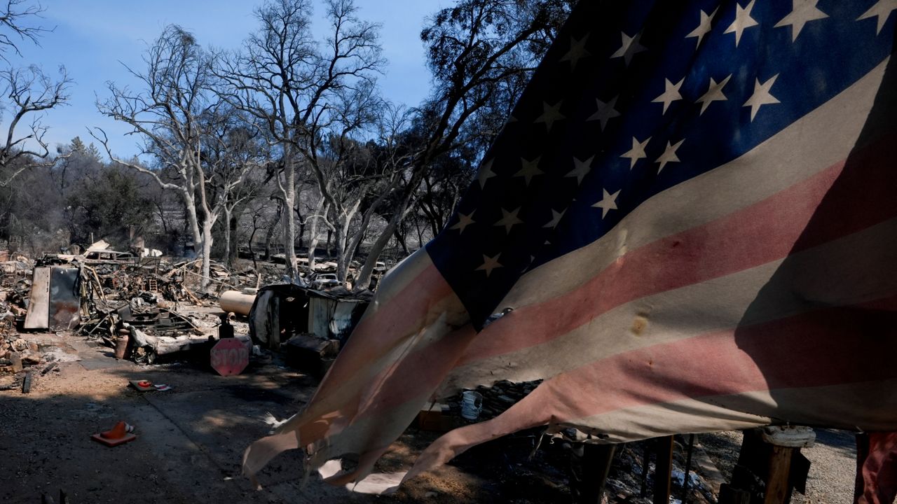 A helicopter flies over the Airport Fire, Sept. 9, 2024, near Trabuco Canyon, Calif. (AP Photo/Gregory Bull)