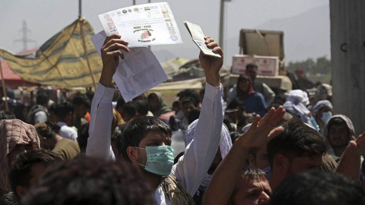 Hundreds of people gather, some holding documents, near an evacuation control checkpoint on the perimeter of the Hamid Karzai International Airport, in Kabul, Afghanistan, Thursday, Aug. 26, 2021. Former interpreters and others who served alongside American troops during the war have been blocked from the airport by Taliban members and sometimes U.S. service members. (AP Photo/Wali Sabawoon)