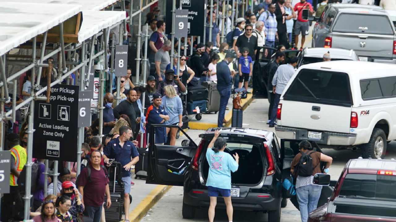 FILE - Travelers are seen outside of Terminal D at George Bush Intercontinental Airport, Friday, July 1, 2022, in Houston. (AP Photo/Julio Cortez)