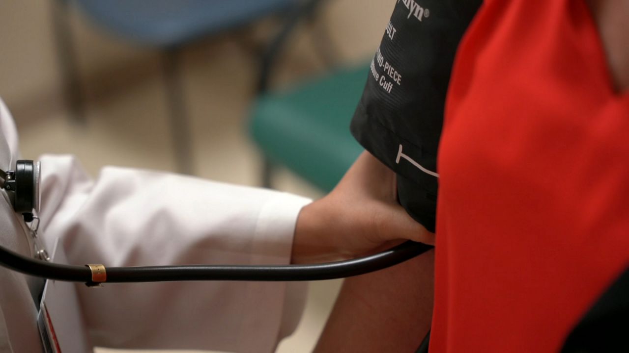 nurse's hand holding a blood pressure sleeve on a patient