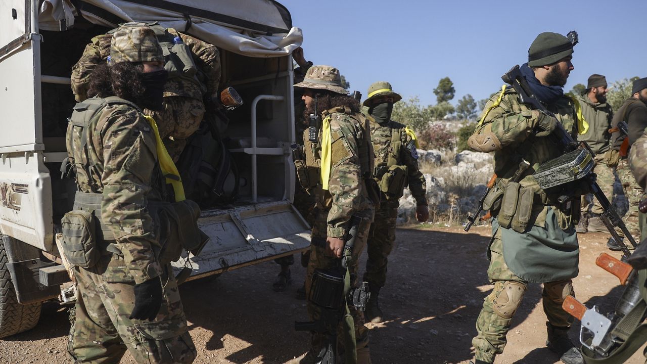 Syrian opposition fighters get off a truck as they enter the village of Anjara, western outskirts of Aleppo, Syria, Thursday Nov. 28, 2024, part of their major offensive on government-controlled areas in the country's northwestern Syria. (AP Photo/Omar Albam)