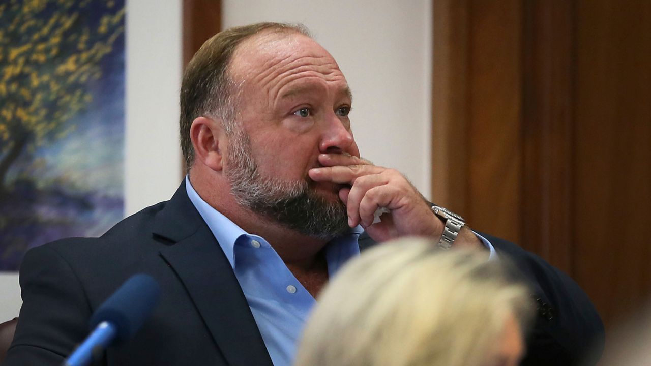 Alex Jones attempts to answer questions about his text messages asked by Mark Bankston, lawyer for Neil Heslin and Scarlett Lewis, during trial at the Travis County Courthouse in Austin, Wednesday Aug. 3, 2022. Jones testified Wednesday that he now understands it was irresponsible of him to declare the Sandy Hook Elementary School massacre a hoax and that he now believes it was “100% real." (Briana Sanchez/Austin American-Statesman via AP, Pool)