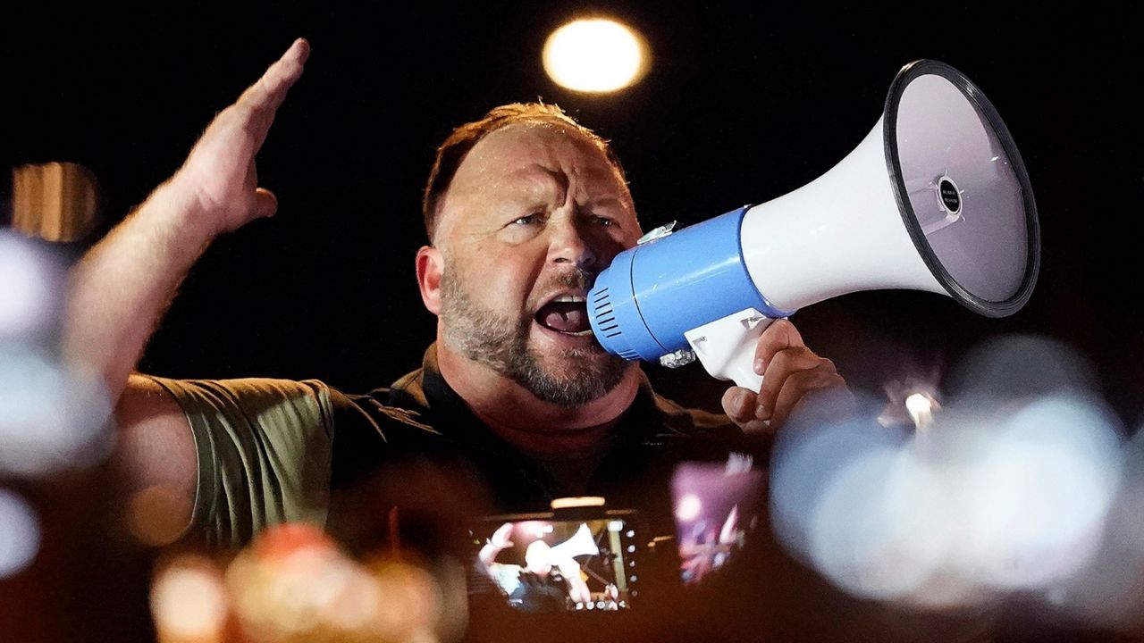 Infowars host and conspiracy theorist Alex Jones rallies pro-Trump supporters, Nov. 5, 2020, in Phoenix. A federal bankruptcy judge has cleared the way for a defamation lawsuit, filed by relatives of some victims of the 2012 massacre at Sandy Hook Elementary School in Newtown, Connecticut, to proceed against Jones. (AP Photo/Matt York, File)