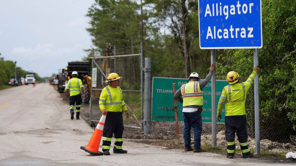 Workers install a sign reading “Alligator Alcatraz” at the entrance of a new migrant detention facility in Collier County in Florida on June 30. (AP Photo/Rebecca Blackwell)