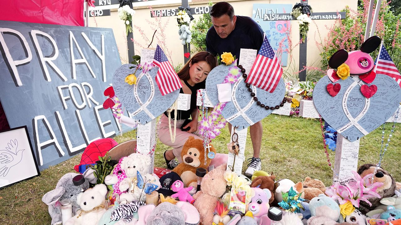  Angela Munoz, leaves a message on a cross with the name, Cindy Cho, as her husband Rick, looks on at a makeshift memorial, Wednesday, May 10, 2023, in Allen, Texas, by the mall where several people were killed. Among the eight people killed when a gunman opened fire at a Texas shopping mall earlier this month were Kyu and Cindy Cho and their 3-year-old son, James. Their family's only survivor that day was their 6-year-old son. (AP Photo/Tony Gutierrez, File)
